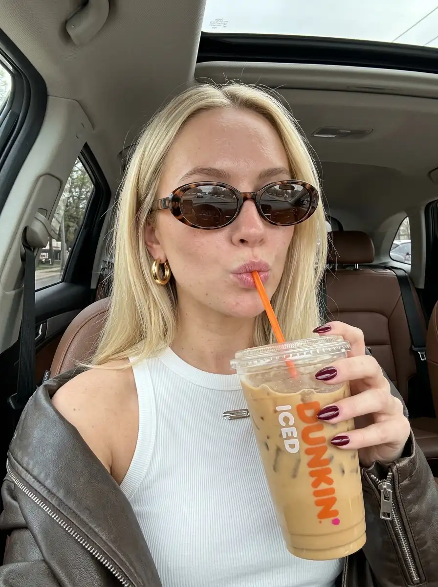 Woman_holding_iced_coffee_car_202607112333